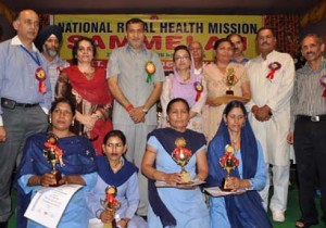 Minister for Health, Sham Lal Sharma giving mementoes to meritorious ASHA workers on Monday.