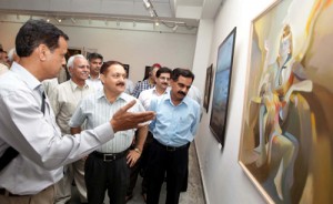 Dr Pawan Kotwal, Divisional Commissioner looking at the paintings displayed in Srijan Samooh’s maiden exhibition at Kala Kendra on Friday.