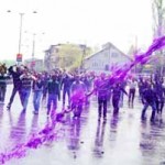 Government employees duck as police lobs coloured water cannons on them in Srinagar on Tuesday. -Excelsior/Amin War