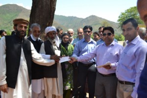 MLA Aijaz Ahmed Jan handing over cheques among the beneficiaries at Khanater, Poonch on Tuesday
