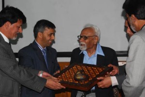 Officials of MERC presenting gift to Prof Manzoor-ul-Amin at Kashmir Varsity on Monday.