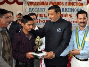 Minister for PHE, Sham Lal Sharma giving award to a meritorious student at Akhnoor on Friday.