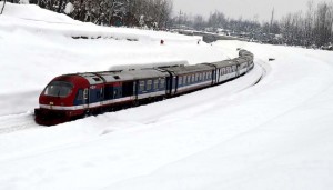 A passenger train runs through snowbound areas at Qazigund in South Kashmir on Thursday. Another pic on page 6 (UNI)