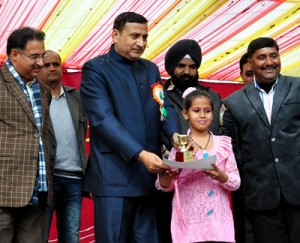 Minister for PHE, Irrigation and Flood Control, Sham Lal Sharma felicitating a student during an annual day function of a school in Akhnoor.