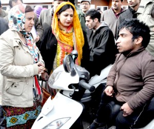 Minister for Social Welfare Sakina Itoo distributing motorized tricycle to a handicapped on Tuesday. 