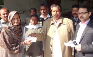 Minister for Housing Raman Bhalla distributing cheque to a beneficiary at Jammu on Tuesday.