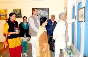 Triloke Kaul along with others having round of the painting exhibition at Jammu on Thursday.