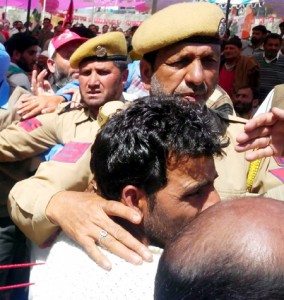 The youth who was slapped by NC Minister Mohammad Akbar Lone being whisked away by police from Rafiabad rally on Tuesday.