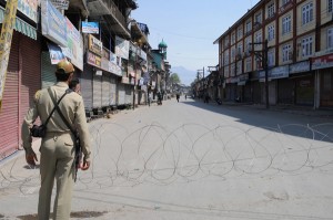 A paramilitary soldier stands guard at a barricade during restrictions in Srinagar on Thursday. -Excelsior /Amin War