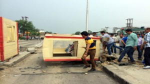 BJP activists smashing Toll Plaza at Sarore on Tuesday. 	-Excelsior/Gautam