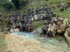 Army and police personnel pose with arms, ammunition and explosive devices seized at Keshwan in Kishtwar district on Sunday.-Photo by Jamwal