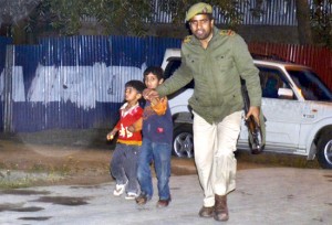 A jawan rescues two children to safety during an encounter with militants in Sopore on Sunday. -Excelsior/Aabid Nabi