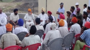 Retd SSP Bhupinder Singh interacting with the people at RS Pura on Monday.