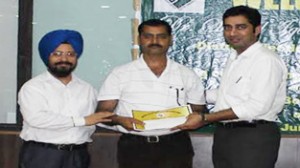 Deputy Commissioner Dr Shahid Iqbal Choudhary handing over cash prize and certificate to an official at Reasi on Sunday. 