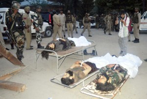 Security personnel stand near the bodies of slain militants in South Kashmir’s Tral town on Thursday.—Excelsior/Sajad Dar