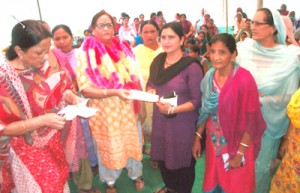 MLA Bimla Luthra distributing cheque to a beneficiary at Bishnah on Wednesday.