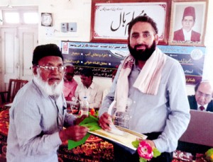 Urdu writer, Dr Mushtaq Ahmed Wani receiving ‘Waqaar-e-Adab’ award from a dignitary at Malegaon in Maharashtra.