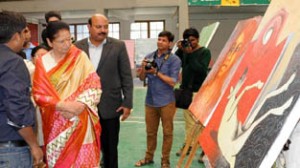 Usha Vohra having a look at paintings during Art Exhibition on Saturday .