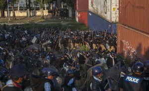 Riot police run away from supporters of Tahir ul-Quadri, Sufi cleric and leader of political party Pakistan Awami Tehreek (PAT), during the Revolution March in Islamabad on Sunday.