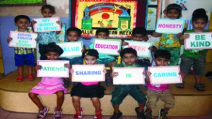 Children displaying placards while posing for a group photograph during ‘Value Education Week’.