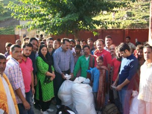 MLC Jugal Kishore distributing relief material among landslide hit villagers of Saddal on Monday. 