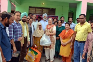 JU VC Prof M P S Ishar and his wife Lida Singh alongwith others distributing relief among flood hit villagers.