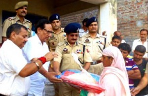 DIG Jammu Shakeel Beig distributing relief material to flood victims at Pouni Chak on Sunday.