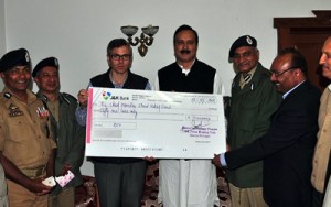 Minister of State for Home, Sajjad A Kichloo presenting a cheque to Chief Minister Omar Abdullah at Srinagar on Tuesday.