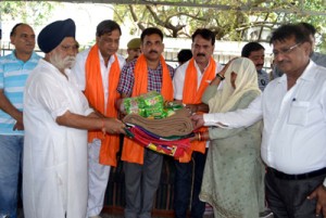 Minister of State for Cooperative, Dr. Manohar Lal Sharma  distributing relief material at Dera Baba on Tuesday.