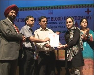 A voluntary blood donor being honoured by dignitaries during celebration of National Voluntary Blood Donation Day at Police Auditorium in Jammu.