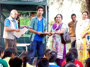 A dignitary presenting participation certificate to a student on the concluding day of nature camps at Dudu Valley.