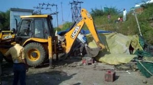 JCB removing encroachment in Transport Nagar area of Jammu on Thursday.