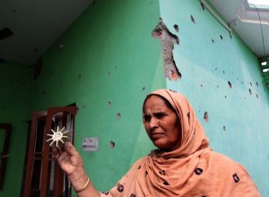 A woman stands in front of her  badly damaged house, which was hit by mortar shells and bullets at Kaku-De-Kothe in Arnia sector on Saturday. Another pic on page 9.-Excelsior/Rakesh