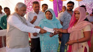 Minister for Planning, Ajay Sadhotra distributing cheque among the beneficiaries in block Marh on Tuesday.