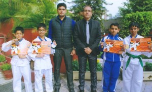 Medal winning karatekas of KC Public School posing along with Principal Amarendra Mishra and coach Ambedkar Gupta.