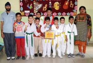 Taekwondo players of Rich Harvest School posing for a group photograph after winning medals.