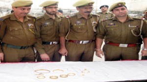 Police officers showing gold items recovered from thieves and  jewelers at Janipur police station. -Excelsior/Rakesh