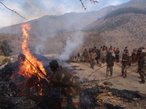 Army personnel engaged in dousing fire in village Jangalwar in district Doda. 