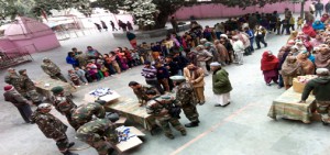 Border migrants wait for relief material at Chichi Mata Ji temple in Samba on Sunday. -Excelsior/Gautam