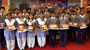 Students of Naveen Shiksha Kendra High School, Bala Enclave, Channi-Himmat holding uniforms while posing for a group photograph.