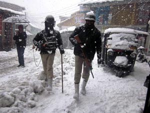 CRPF men on duty moving through snowfall at Seri Bazar in Bhaderwah on Tuesday. —Excelsior/Tilak Raj