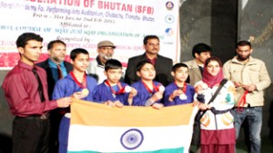 Victorious Sqay players of Jammu and Kashmir holding Indian National Flag while posing for a group photograph. 