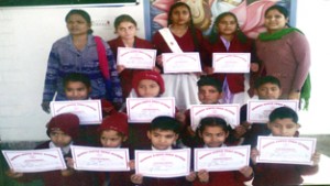 Winners of Essay Writing Competition displaying certificates while posing for a group photograph.