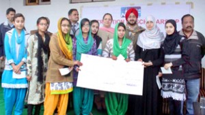 Students displaying Scholarship cheques presented to them by NHPC Limited in Jammu on Thursday.