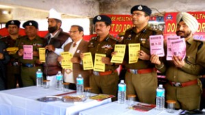 Officers of J&K Police pamphlets displaying indicating ill effects of drugs during an awareness camp at Bus Stand, Jammu. 
