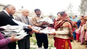 Members of APS, J&K, distributing cooking utensils among flood affected people at Sure Chak in Phalain Mandal area of Jammu.