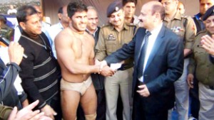 Winner of wrestling competition being awarded by diginitaries.