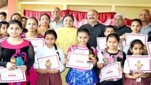 Students displaying certificates of merit and trophies during Annual results function at DBN School Mubarak Mandi in Jammu.