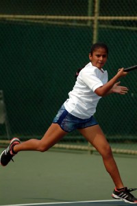Prinkle executing a fore-hand smash during a Lawn Tennis match that took her to quarterfinals at Thailand.