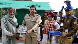 CRPF officer giving goods to flood victim at Reasi.